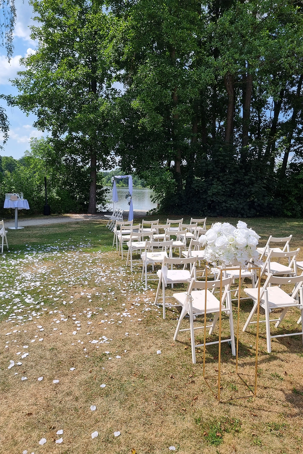 Ein stimmungsvoller Hochzeitssaal im Freien mit Blick auf einen See.