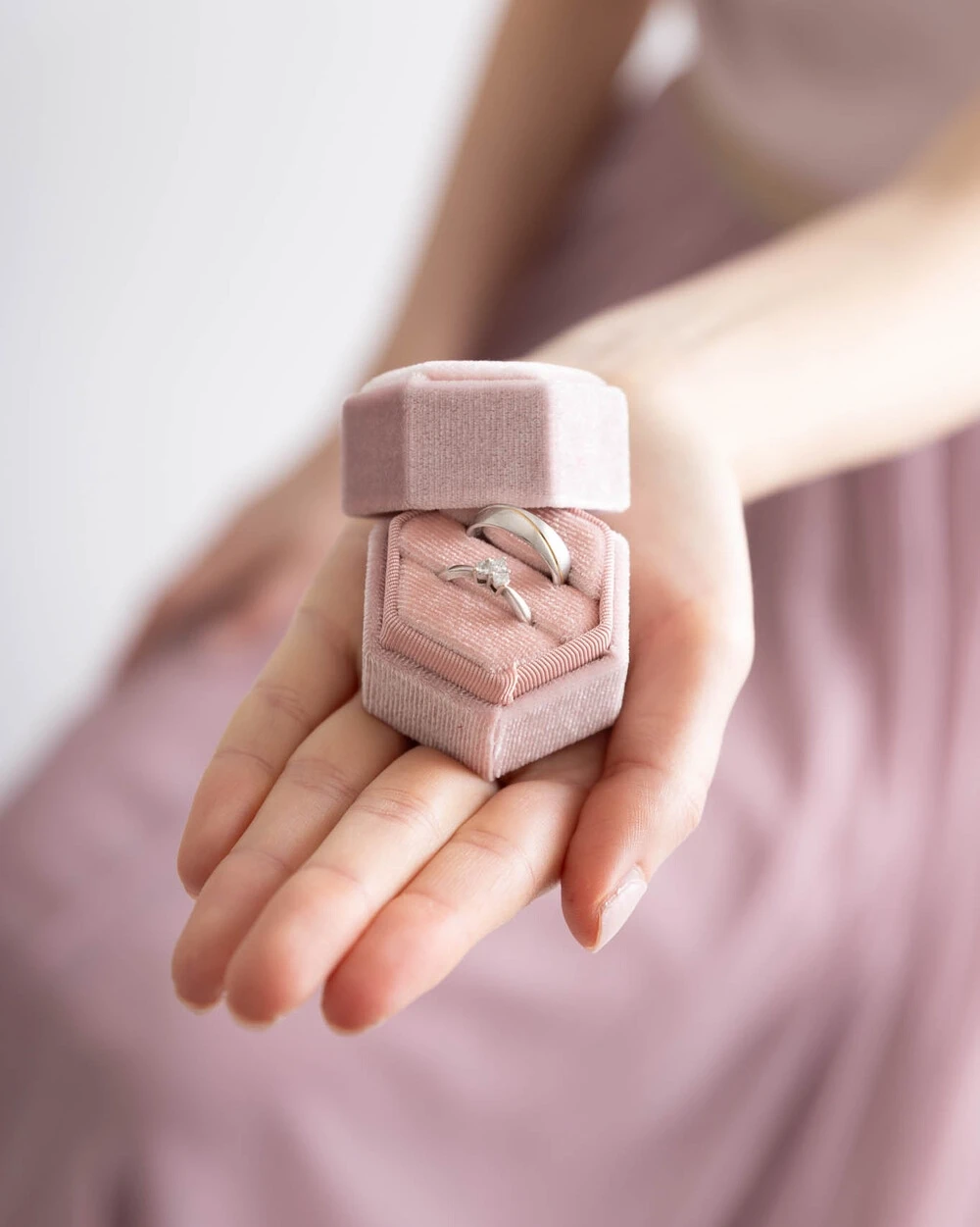 Jasmin hält eine Schattulle mit Eheringen in der Hand